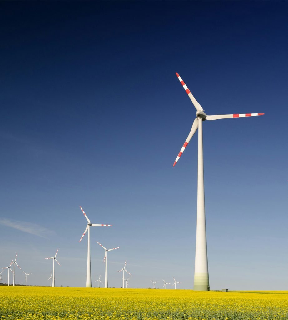 white wind turbines under a vivid blue sky