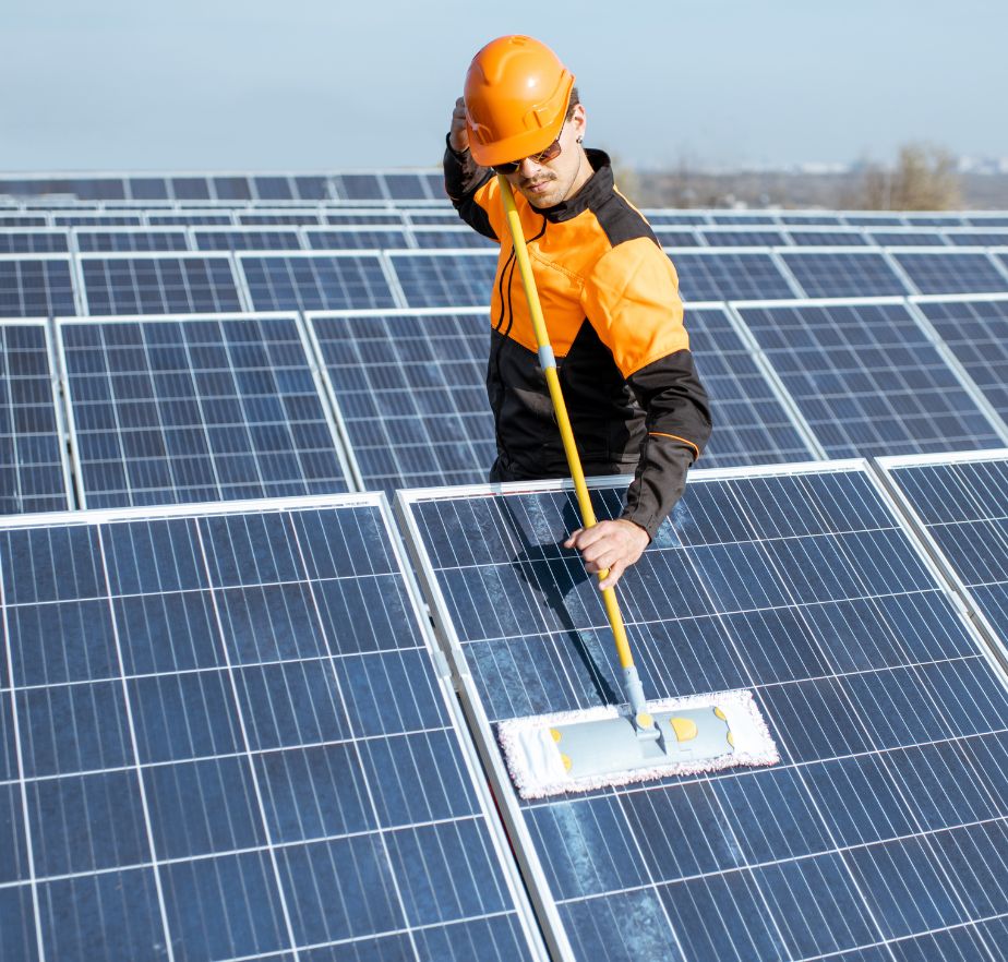 A professional cleaning a solar panel's surface