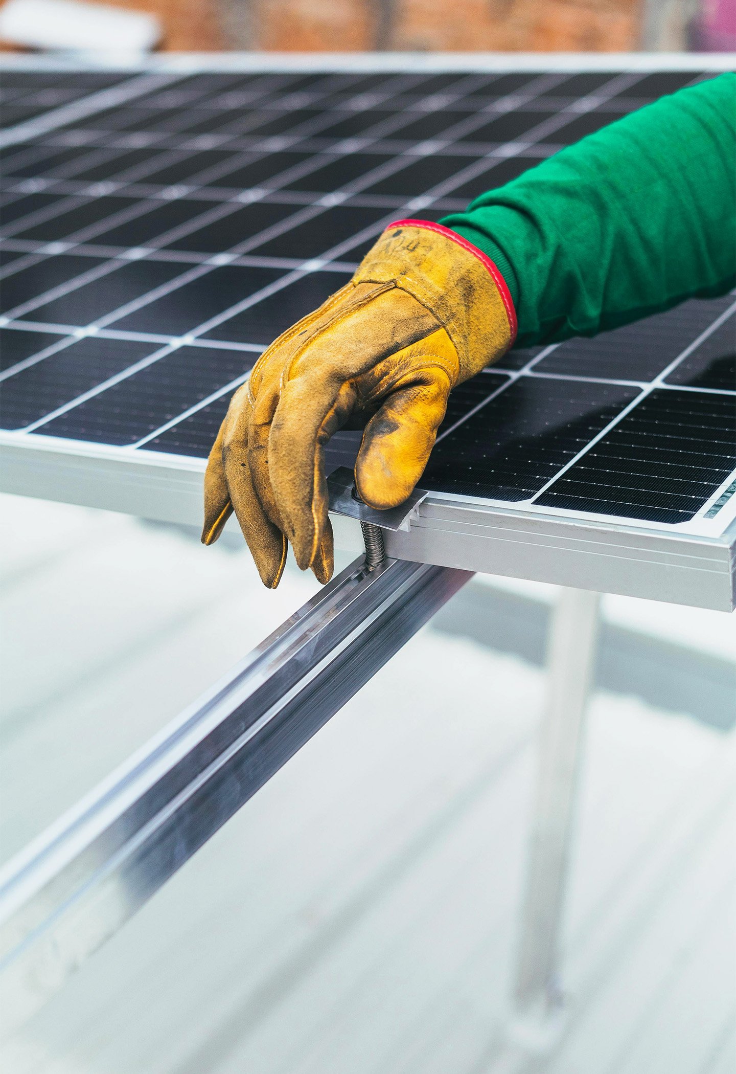gloved hand on top of a solar panel
