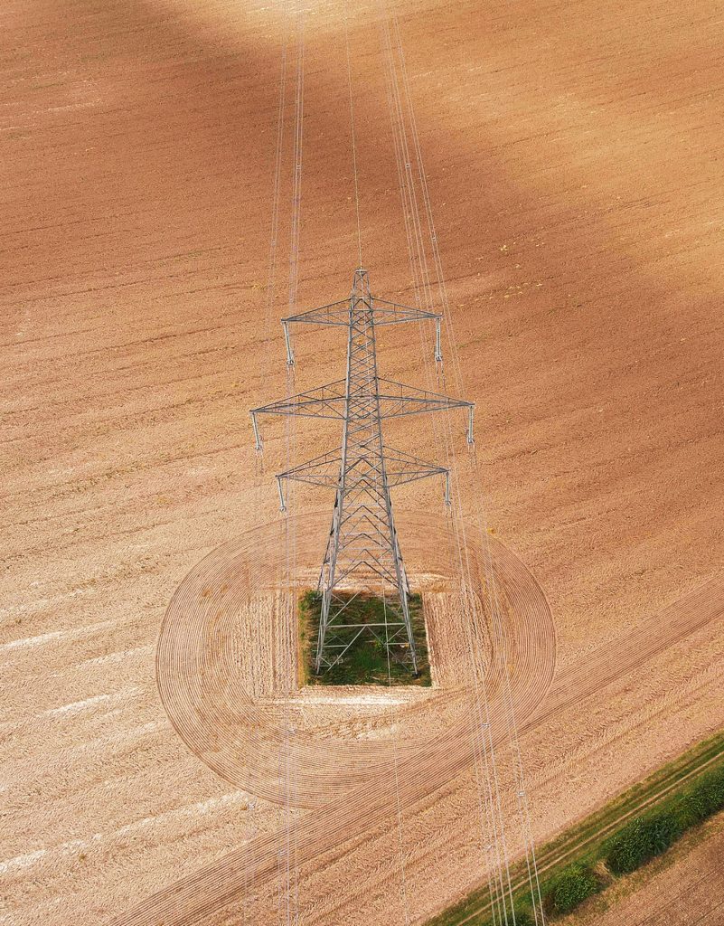 Drone shot of a transmission tower on field