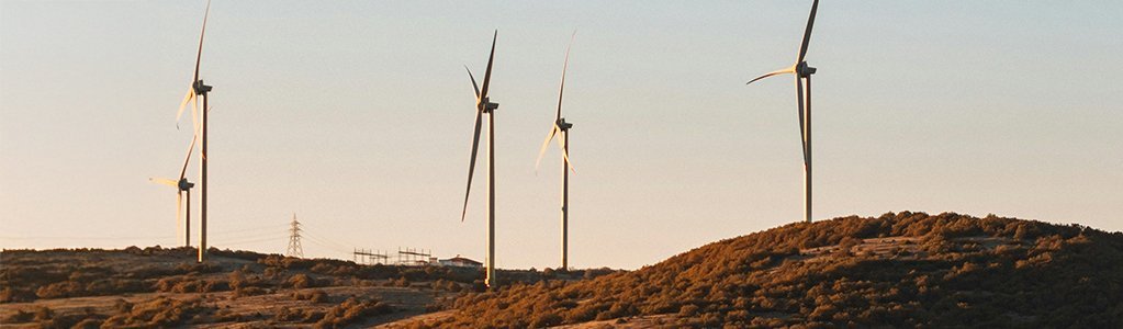 side view of wind turbines on a hill