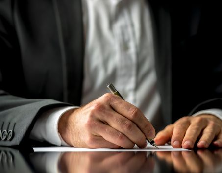A person writing down his assets in a piece of paper