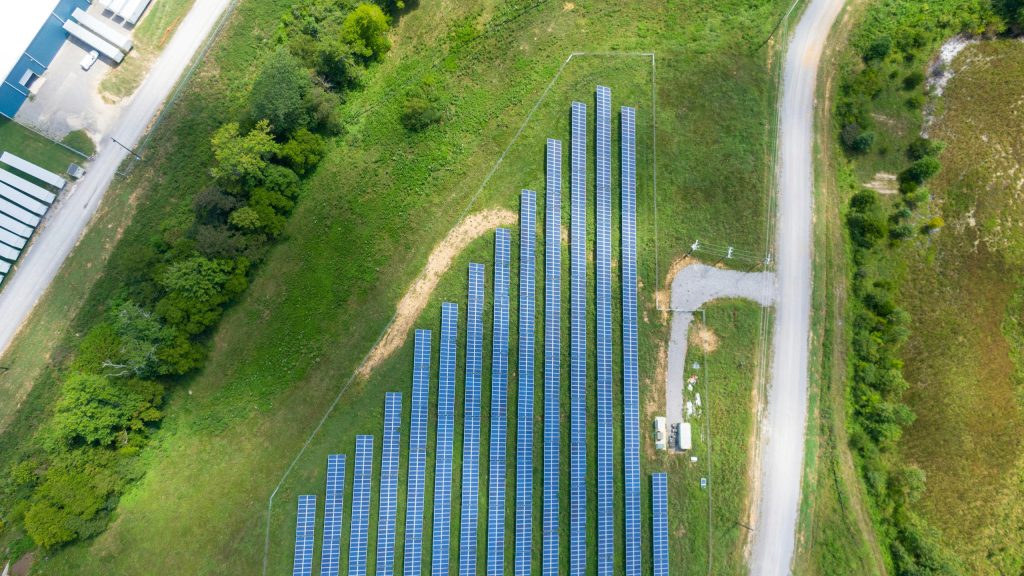 Aerial view of solar farm surrounded by green fields