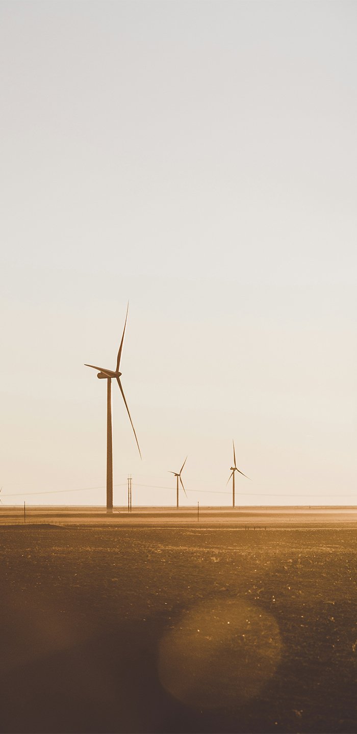 Several wind turbines in the distance during sunset