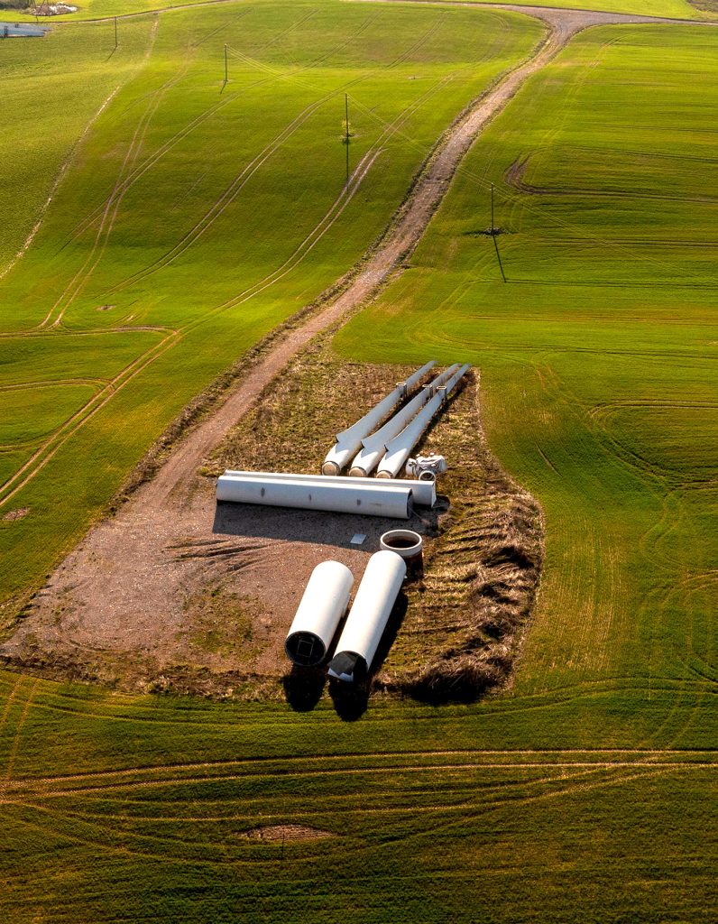 Aerial view of wind turbine parts in the middle of a field