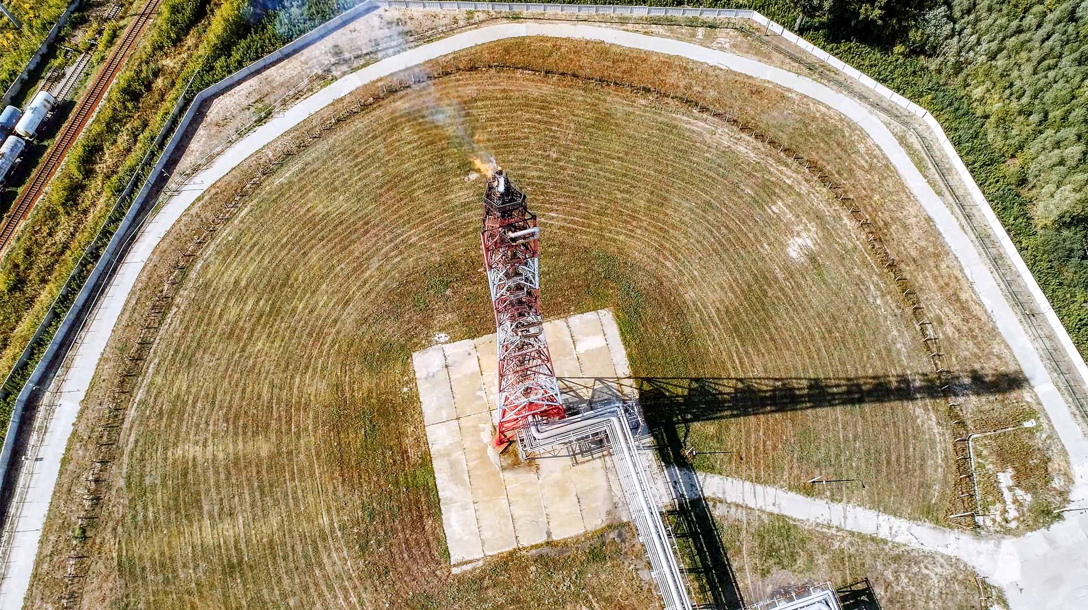 Aerial view of a red and white landfill gas flare stack